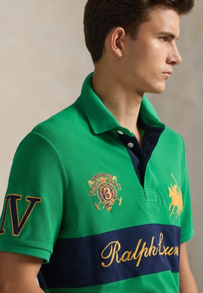 Πράσινο πόλο μπλουζάκι με ναυτικό ρίγα, κεντημένα λογότυπα και το όνομα "Ralph Lauren" σε χρυσό. Διαθέτει κλασικό γιακά και κουμπότρυπα.