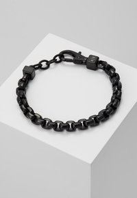 Bracelet en chaîne noire composé de maillons en métal brillant, avec des accents carrés et un fermoir. Surface lisse avec un design minimaliste.