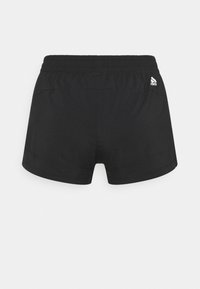 Shorts de sport noirs avec une taille élastique, texture lisse et un petit logo blanc sur le côté droit à l'arrière. Design simple et fonctionnel.