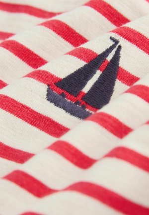 Material cu dungi roșii și albe, cu un detaliu brodat al unei bărci cu pânze albastre. Textură moale, material predominant bumbac, pliat cu grijă.