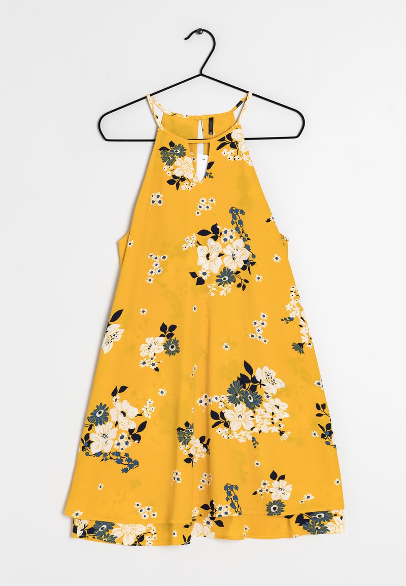 Robe jaune sans manches avec des motifs floraux blancs et bleu foncé accrochée à un cintre noir sur un fond blanc.