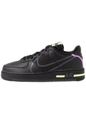 Sort Nike Air sneaker med mesh og læder overdel, neon gule accenter på sålen og lilla detalje på hælen mod hvid baggrund.