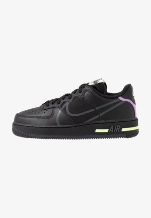 Czarny sneaker Nike Air z siateczki i skóry, z neonowo-żółtymi akcentami na podeszwie oraz fioletowym detalem na pięcie na białym tle.