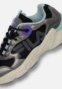Sneaker nero e grigio con tomaia in rete, dettagli in azzurro chiaro, suola spessa e branding in viola. Presenta lacci e occhielli testurizzati.