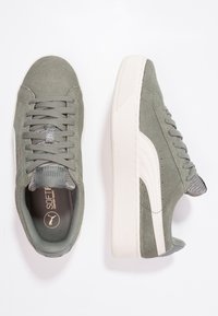 Sneaker in suede verde con suola in gomma crema, dettagli in mesh testurizzato e lacci. Presenta un logo e dettagli cuciti per un tocco di design in più.