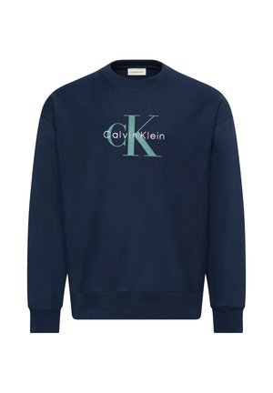 Sudadera azul marino de cuello redondo con mangas largas, con un gran logo "cK" en azul claro y "Calvin Klein" en blanco en el frente.