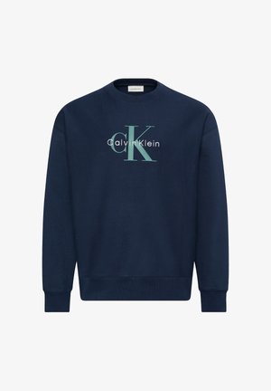 Sudadera azul marino de cuello redondo con mangas largas, con un gran logo "cK" en azul claro y "Calvin Klein" en blanco en el frente.