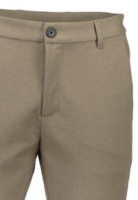 Pantalons kaki avec une texture lisse, dotés d'une fermeture à bouton, de poches latérales discrètes et d'une coupe ajustée. Design simple avec des lignes épurées.
