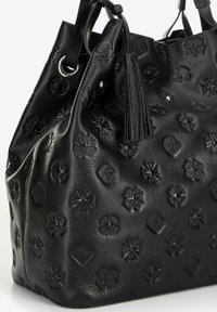 Czarna torebka skórzana o teksturowanej powierzchni z wytłoczonymi wzorami kwiatowymi i monogramami, z dwoma uchwytami i frędzlami po boku.