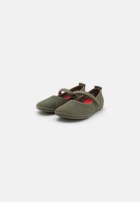 Zapatillas de malla verde oliva con punta redonda, suela plana y dos correas elásticas cruzando el empeine. Parte superior texturizada con perforaciones sutiles.