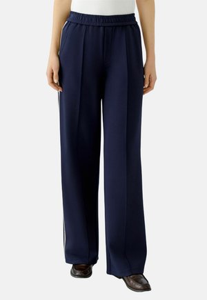 Marineblauwe wijde broek met een elastische tailleband en twee zijzakken, voorzien van witte zijstrepen en een zachte, lichtgewicht stof.