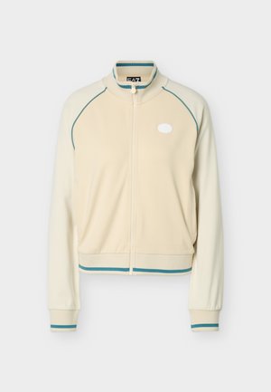 Krēmkrāsas rāvējslēdzēja sporta jaka ar tirkīza krāsas maliņām plecos, apkaklī, aprocēs un apakšmalā, ar mazu baltu logotipu uz kreisā krūtīm.