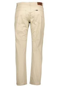 Beżowe spodnie bawełniane o prostym kroju nogawki, z dwoma tylnymi kieszeniami i brązową skórzaną łatą nad paskiem.