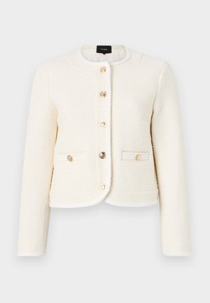 White textured jacket with a rounded collar, gold buttons, two front pockets, and contrasting trim along the edges and collar.