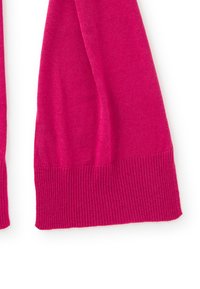Pull en tricot rose à manches longues, avec des poignets côtelés et une texture lisse. Design simple, sans motifs ni accessoires supplémentaires.
