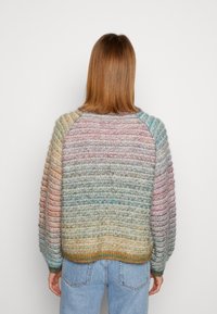 Maglione a maglia multicolore con una superficie morbida e strutturata. Presenta un collo rotondo, maniche raglan e una vestibilità ampia.