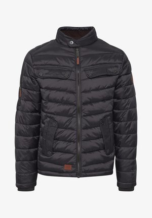 Musta puffatakki etuvetoketjulla, napillisia hihansuita ja kaksi rintataskua. Teksturoitu kangas vaakasuoralla tikatulla kuviolla ja ruskealla nahkaakennella.