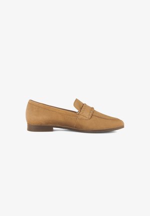 Bruine suède platte loafer met lage hak en een gestikte band over de bovenkant, zijaanzicht op een witte achtergrond.