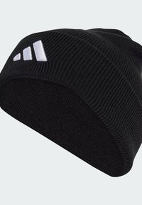 Czarna dziana czapka z prążkowanym wzorem. Posiada białe haftowane logo składające się z trzech ukośnych pasków.