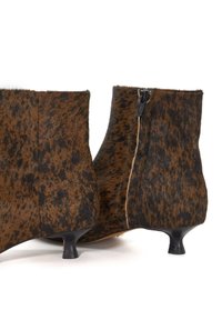 Brown leather ankle boots featuring a spotted texture, zip closure, and kitten heels, designed with a smooth, rounded shape.
