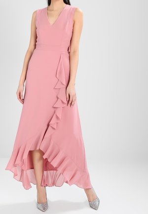 Maxikjole i blødt rosa stof med V-udskæring, flæsekant og sideaccent, med et høj-lavt design. Kombineret med sølvfarvede hæle.