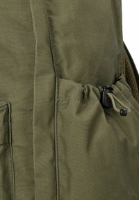 Poche en tissu vert avec un verrou de cordon noir réglable, faisant partie d'un vêtement ou d'un sac, vue en gros plan montrant les détails de couture et de texture.