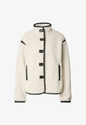 Kremfarget shearlingjakke med stående krage, fem knappelukkinger, og svart skinnkant langs kanter og lommer.