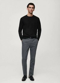 Maglietta nera a maniche lunghe, pantaloni grigi su misura, cintura nera e scarpe nere. Design semplice con una silhouette aderente e una texture liscia.
