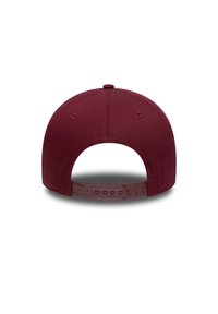 Gorra de béisbol en color burdeos con una textura suave, parte trasera cerrada, correa de plástico ajustable y ojales de ventilación en la corona redondeada.