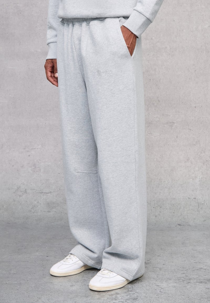 Pantalones deportivos grises hechos de una suave mezcla de algodón, con un corte relajado, cinturilla elástica, bolsillos laterales y un discreto bordado del logo.