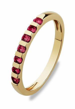 Goldring mit glatter Oberfläche, der sieben runde rosa Edelsteine in einer geraden Reihe zeigt, abwechselnd mit kleinen Goldakzenten.
