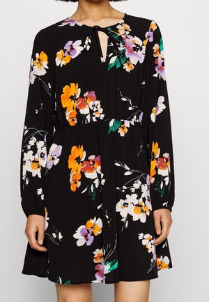 Robe noire à manches longues avec imprimé floral orange, violet et blanc, taille élastique et détail lien au niveau de l'encolure.