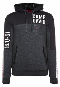 Sweat à capuche gris foncé et noir avec texte "CAMP DAVID", poches zippées, et chiffres imprimés blancs et rouges sur les manches.