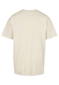 Beige bomull T-skjorte med korte ermer, rund hals og rett søm. Jevn tekstur uten synlige mønstre eller detaljer.