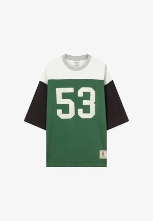 Short-sleeve shirt with green and white blocks, black sleeves, gray collar, large white "53" on front, and a small tag at the bottom right.