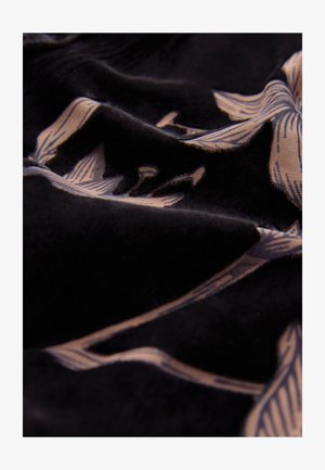 Juoda audinys su lygiu paviršiumi, puoštas šviesiai smėlio spalvos gėlių raštu. Dizainą sudaro pailgi žiedlapiai ir lenktos linijos.