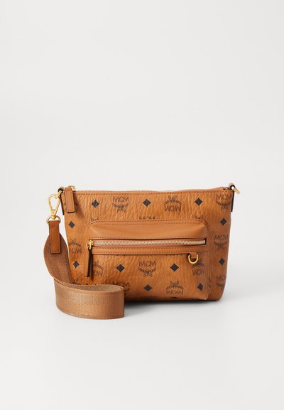 Tan läder crossbody-väska med präglade mönster, har en framficka med dragkedja, säker dragkedjestängning och justerbar rem.