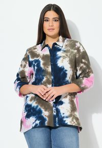 Camisa de tie-dye con patrones en azul, rosa y marrón. Diseño con cuello, cierre de botones, mangas largas arremangadas y tejido ligero.