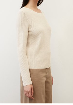 Beige svetr s žebrovaným pletením, dlouhými rukávy a kulatým výstřihem, v kombinaci s světle hnědými kalhotami. Hladká textura a přiléhavý střih.