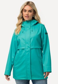 Turkos vattentät jacka med huva, justerbara snoddar, framfickor och en avslappnad passform. Slät textur och stilren finish.