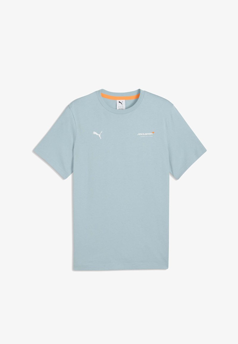 T-shirt Puma bleu clair à manches courtes avec le logo de l'équipe McLaren de Formule 1 sur la poitrine et un bord intérieur de l'encolure orange.