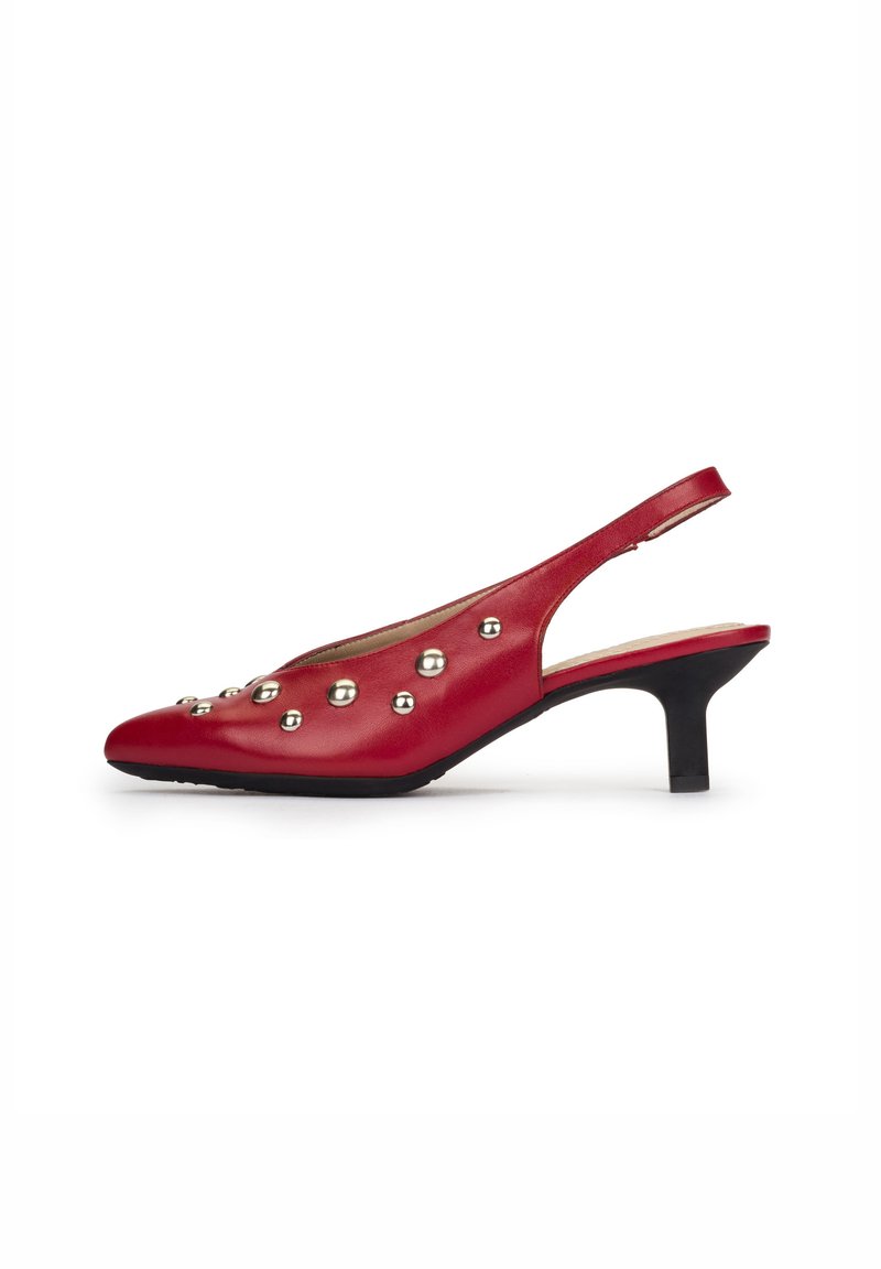 Zapato slingback de cuero rojo con puntera puntiaguda, adornado con tachuelas metálicas plateadas y un tacón bajo negro. Textura suave, diseño simple.