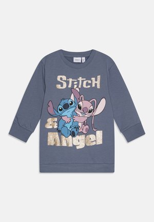 Γκρι φούτερ με μακριά μανίκια που διαθέτει γραφικό με τον Στιτς και την Άντζελ. Το κείμενο λέει "Στιτς & Άντζελ" με χρυσό νιφάδα. Υλικό από βαμβάκι.