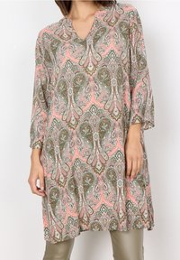 Tunique rose avec un motif paisley, présentant des nuances de vert et de blanc, un décolleté en V et des manches trois-quarts, fabriquée en tissu léger.