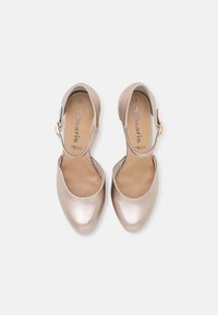 Metalické světle zlaté lodičky na vysokém podpatku s otevřenou špičkou, s křivkovým tvarem a malým páskem kolem kotníku s akcentem zlaté spony.