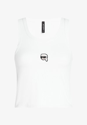 Valge ribikonstruktsiooniga tanktop, millel on kokkuhoidlik disain. Rinnal on väike, tikkimisega kujundatud stiilse näo graafika, millel on prillid.