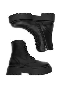 Melnas potītes zābaki, kas izgatavoti no gludas ādas ar masīvu platformu, ar šņorēšanu priekšpusē un sānu rāvējslēdzēju ērtai uzvilkšanai.