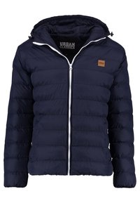 Marineblauwe pufferjas met een capuchon, voorzien van een ritssluiting aan de voorkant, witte accenten, een geborduurd ontwerp en een klein bruin logo op de borst.