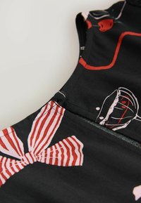 Material textil negru cu un model de fundă în dungi roșii și roz, cu o textură fină și detalii de cusătură vizibile de-a lungul gâtului și marginii.