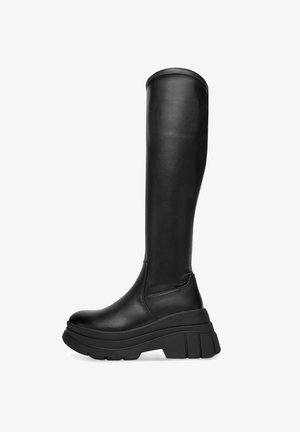 Põlveni ulatuvad mustad nahast saapad paksema platvormtalaga, siledapinnalised ja väikese õmbluse detailiga mööda ülemist äärt.